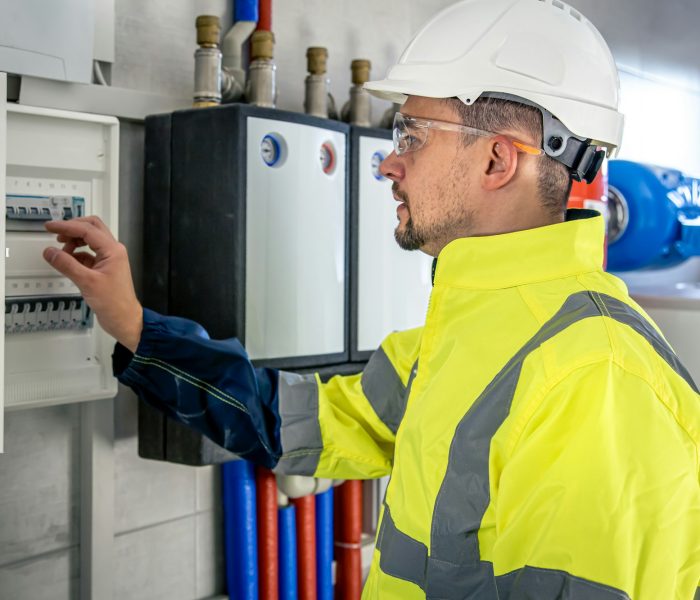 electrical-technician-looking-focused-while-working-in-a-switchboard-with-fuses-.jpg